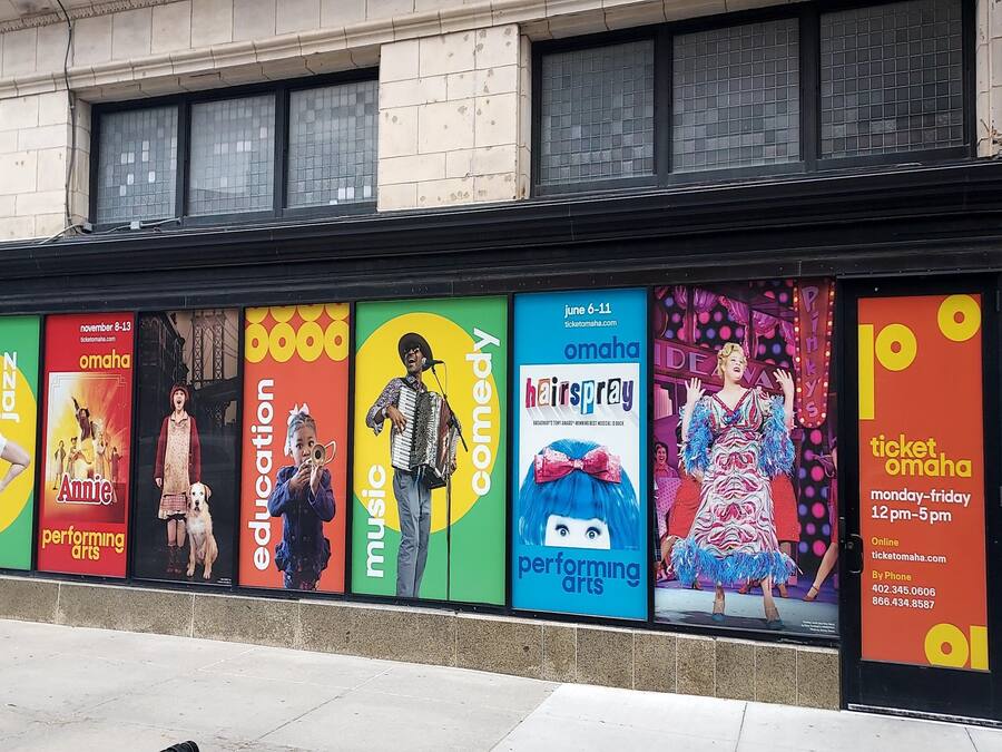 A series of colorful posters advertising various performing arts events at a theater.