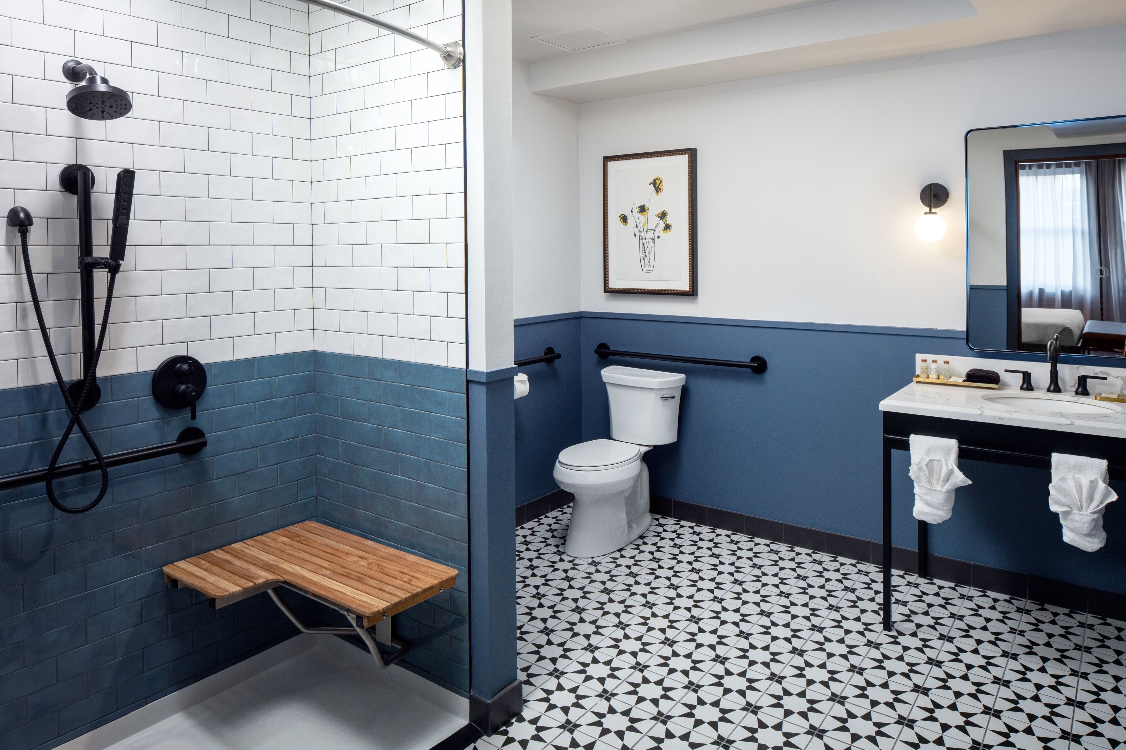 Un baño con ducha, inodoro, lavamanos y un pequeño banco de madera.
