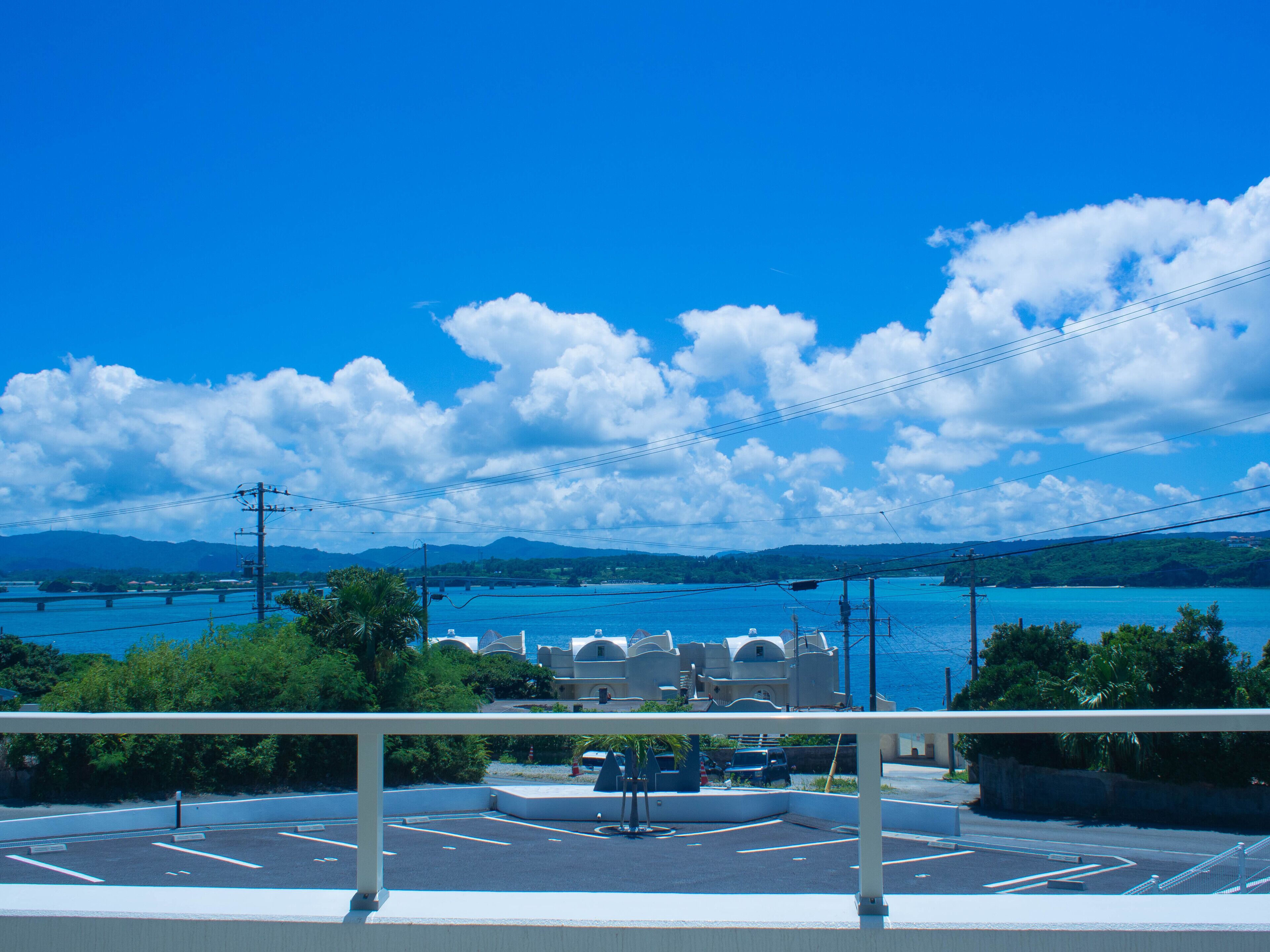 A parking lot with a view of a coastal area, including a body of water and distant mountains.
