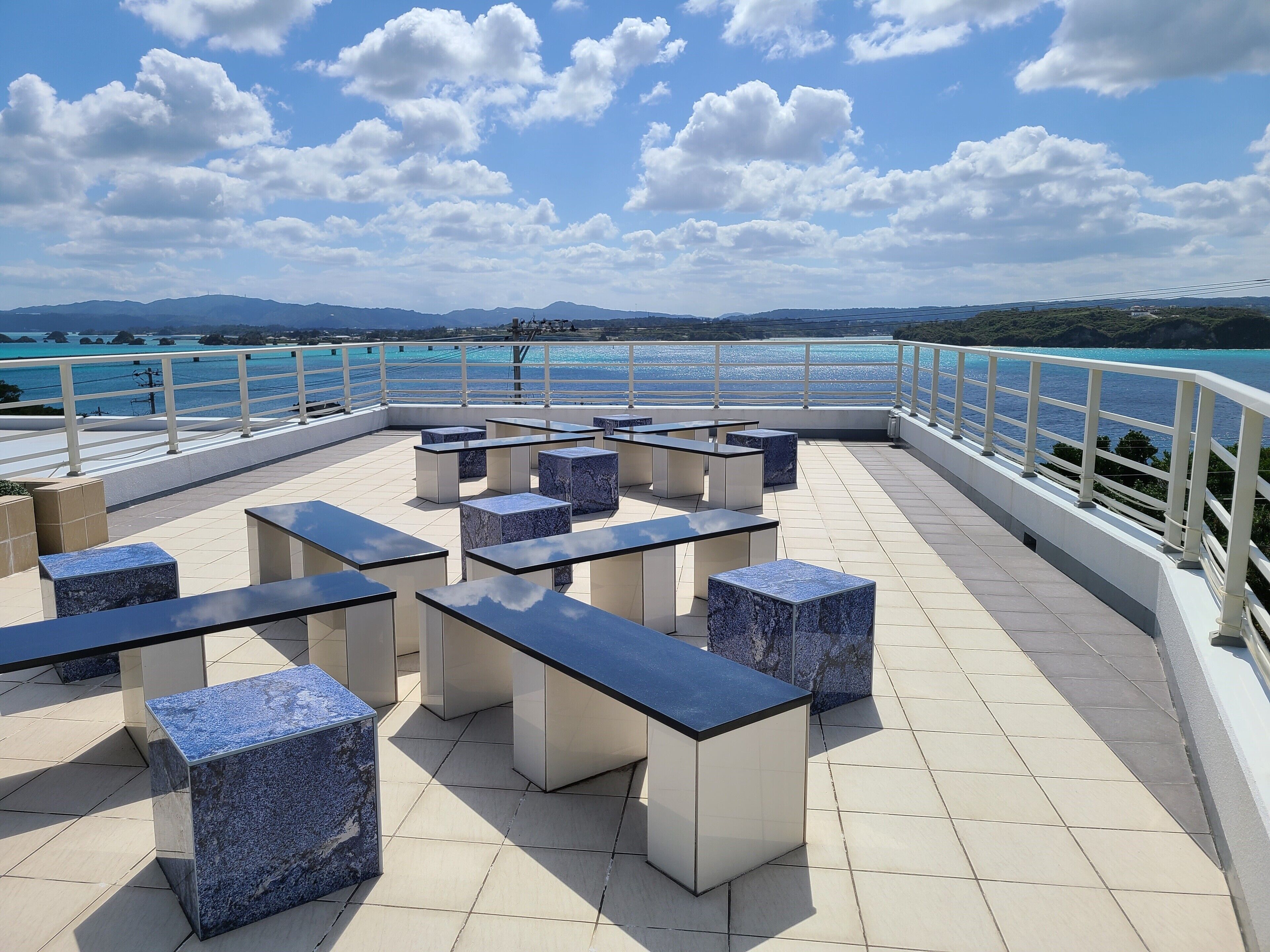 A terrace with seating and a view of the sea.