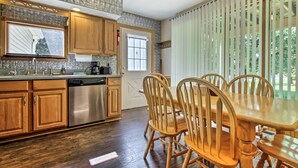 Una cocina moderna con armarios de madera, electrodomésticos de acero inoxidable y un comedor con sillas de madera.