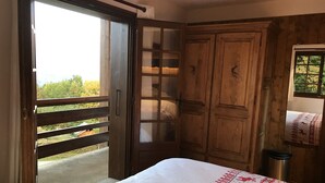 Une chambre à coucher avec un lit, une armoire en bois et un balcon.