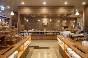 Un moderno comedor para el desayuno con mostradores de madera, sistema de buffet y lámparas colgantes.