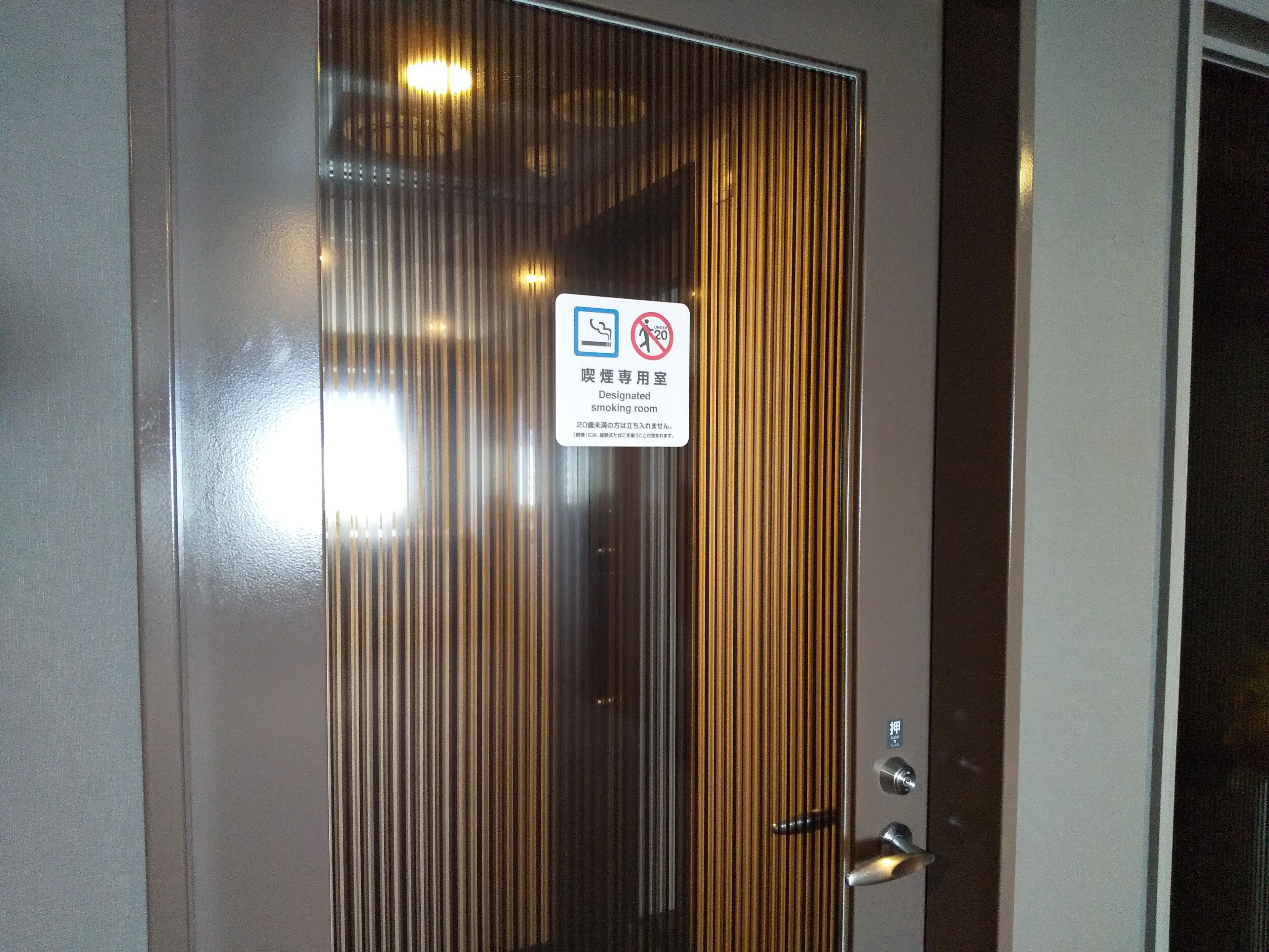 Una puerta con un letrero que indica una sala de fumadores designada.