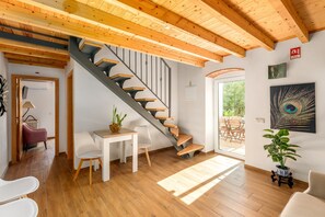 A modern interior with a wooden staircase, a dining area, and a large window. - Charming "Villa Rodrigues" with Air Conditioning, Wi-Fi, Pool & Garden (Boliqueime)