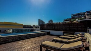 A rooftop with a pool, lounge chairs, and a view of the city skyline. - Luxury 2 Bedroom With Roof Deck and Pool Dewaterkant (Cape Town)