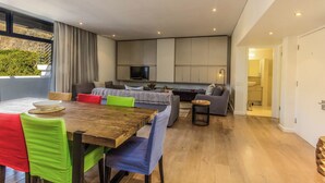 A modern interior with a dining area, sofas, and a kitchen. - Luxury 2 Bedroom With Roof Deck and Pool Dewaterkant (Cape Town)