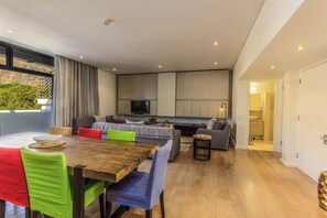A modern interior with a dining area, sofas, and a kitchen.