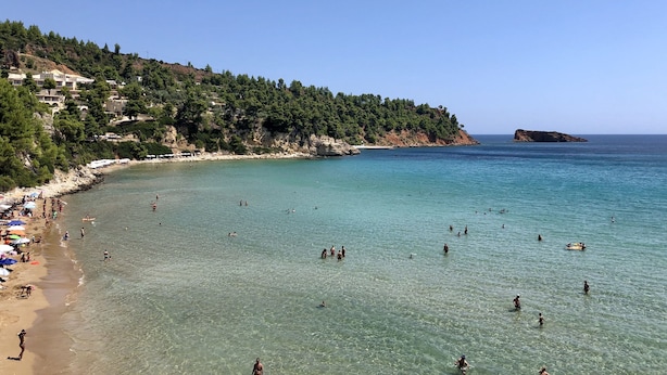 A beach with clear turquoise water, a rocky coastline, and a forested hill. - Alonissos 4-bedroom Large Villa With Private Pool (Alonissos)