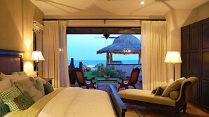 A hotel room with a bed, two chairs, a table, and a view of the ocean. - Relax by Your Private Pool, San Jose Del Cabo 1041 (San Jose Del Cabo)