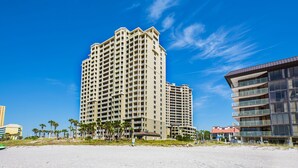 A high-rise hotel with multiple balconies and a beach view.