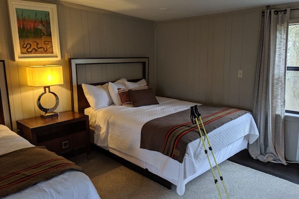 2 Queen beds offer comfort surrounded by woodland views.