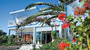 A two-story hotel with a balcony, a covered entrance, and a sign that reads "Hotel". - Kalloudis Apartment (Kos)