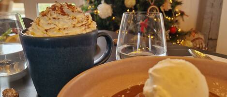 Una mesa con un postre, un árbol de Navidad y vistas al exterior.