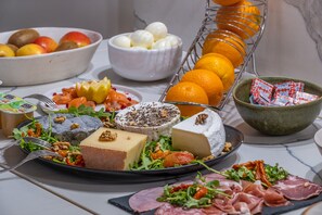 A breakfast buffet with various cheeses, meats, fruits, and a fruit bowl. - La Clef des Chateaux (Maslives)