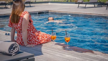 Een seizoensgebonden buitenzwembad, parasols voor strand/zwembad