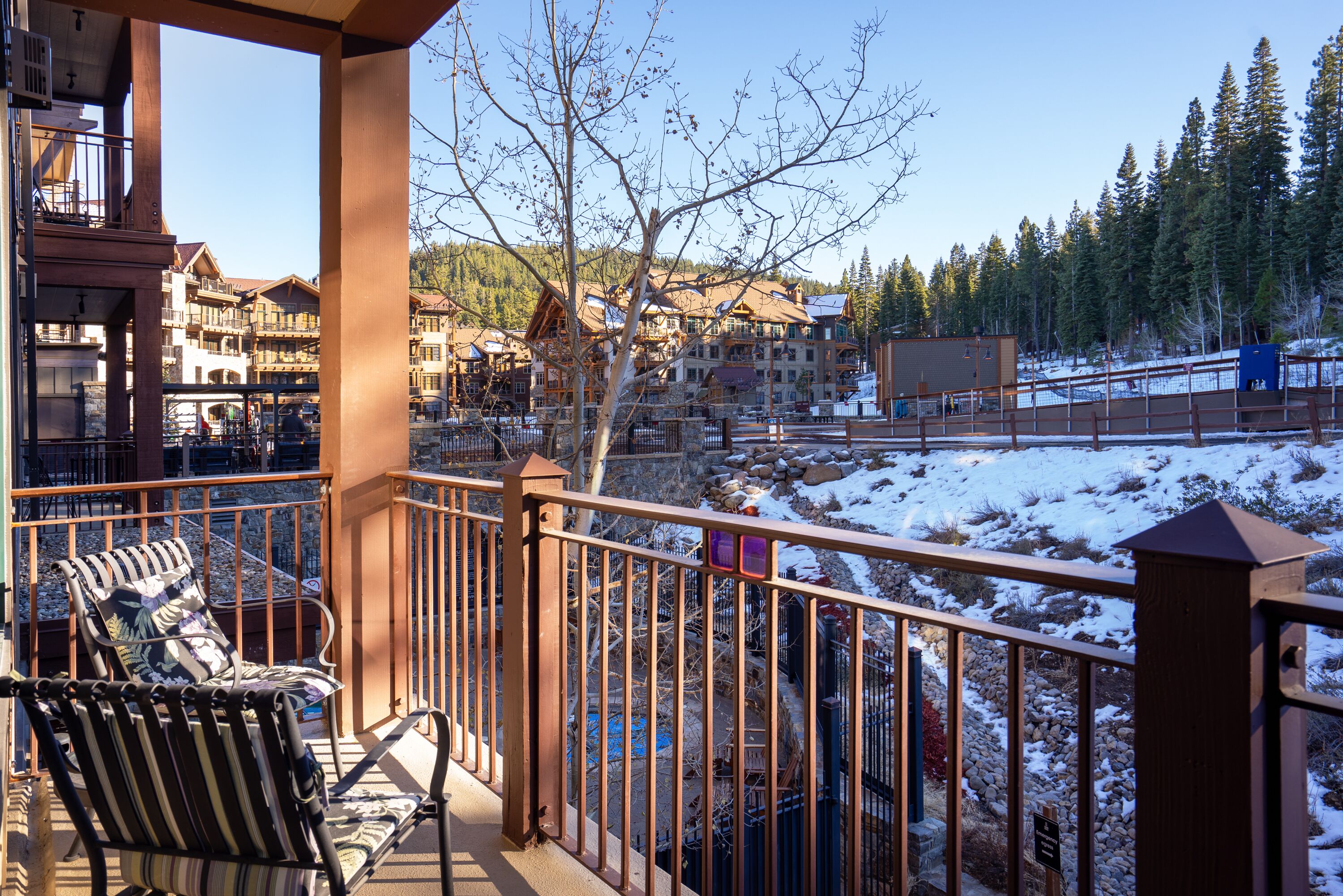 A balcony with a view of a snow-covered landscape and buildings in the background.