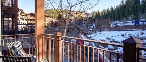 A balcony with a view of a snow-covered landscape and buildings in the background.