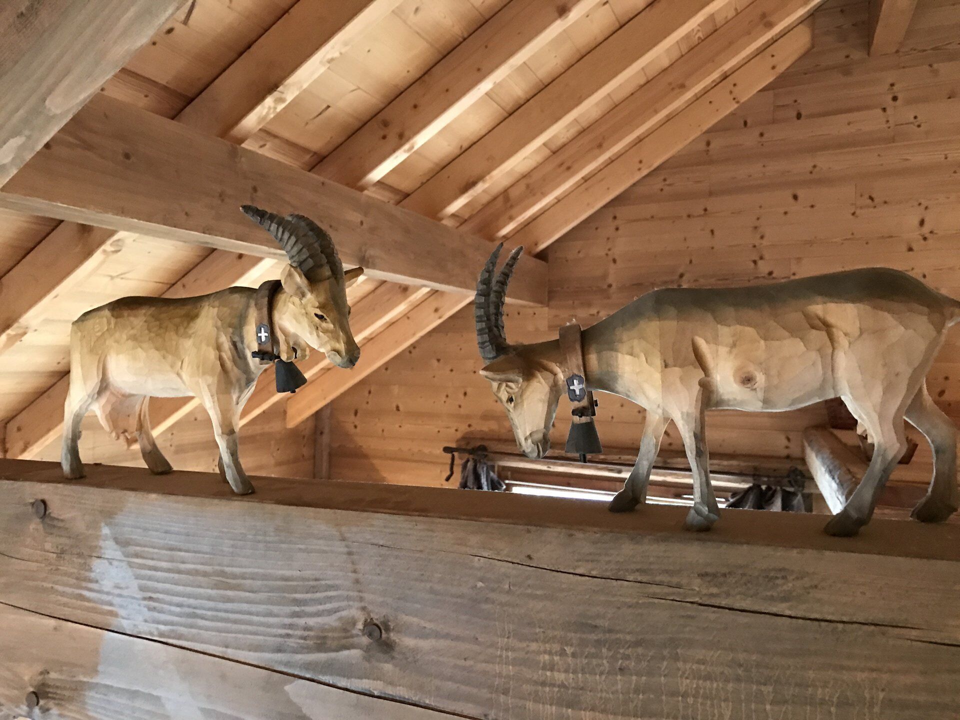 Two mounted antlers in a wooden interior with slanted ceilings.