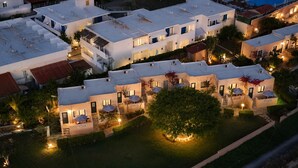 A modern hotel complex with multiple buildings, outdoor seating areas, and a well-maintained garden. - Golden Bay Apartments-garden Haven (Hersonissos)