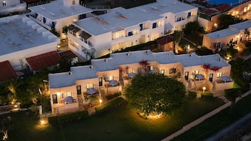 Un moderno complejo hotelero con varias edificaciones, zonas de estar al aire libre y un jardín bien cuidado.