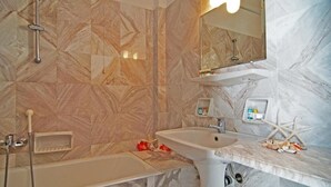 Un baño con bañera, lavamanos y ducha.
