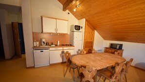 A compact kitchen with wooden cabinets, a microwave, and a dishwasher.