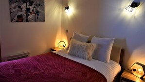 Ein Hotelzimmer mit einem Bett, einem Bild an der Wand und zwei Wandleuchten.