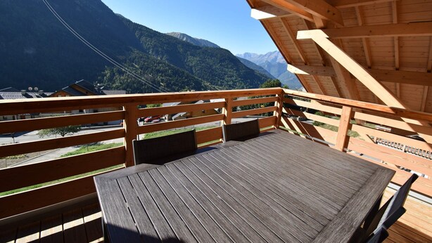 Eine Holzterrasse mit Blick auf ein Gebirge.