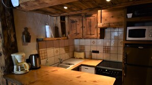 A compact kitchen with wooden cabinets, a microwave, a dishwasher, and a coffee maker.