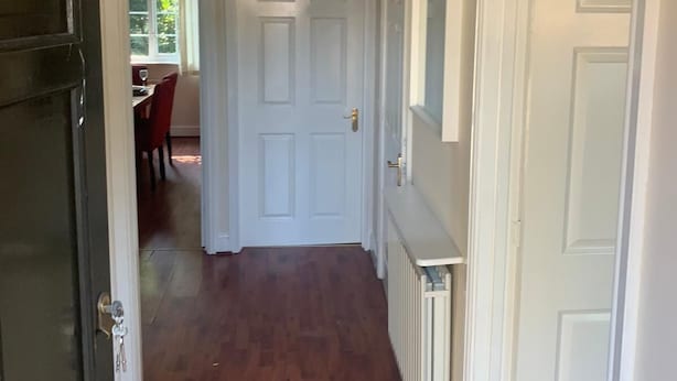 A hallway with wooden flooring, white doors, and a ceiling light fixture. - 3 bedroom house in Reading (Reading)