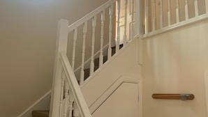 A staircase with white balusters and a handrail, leading to an upper floor. - 3 bedroom house in Reading (Reading)