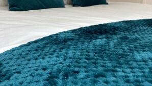 A bed with a teal blanket and two teal pillows. - Modern 1 Bed Apartment (Reading)