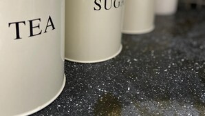 A row of white containers with labels on a speckled countertop. - Modern 1 Bed Apartment (Reading)