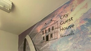 Een affiche van een brug, met daarop de tekst 'City Guest House Newcastle'.