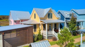 Una hilera de casas coloridas con techos metálicos y una valla de madera al frente.