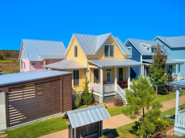 Una hilera de casas coloridas con techos metálicos y una valla de madera al frente.