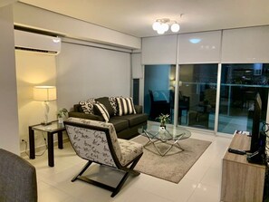 Un salon moderne comprenant un canapé, un fauteuil, une table basse et un meuble pour la télévision.