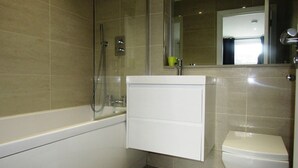 Un baño con bañera, lavabo e inodoro.