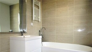 Un baño moderno con una bañera blanca, un lavabo y un inodoro.