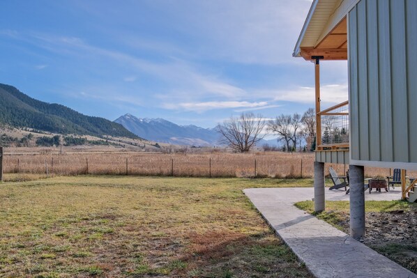 A house with a covered porch, a concrete pathway, and a view of a mountain range. - Evergreen Lane Getaway · River Views and Front Porch Sitting in Paradise (Livingston)