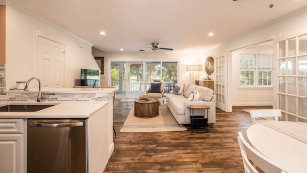 A spacious living area with a kitchen, a dining table, and a sofa. - Fairway Villa w/ Private Pool  (Key West)
