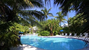 A swimming pool surrounded by palm trees and lounge chairs. - Fairway Villa w/ Private Pool  (Key West)