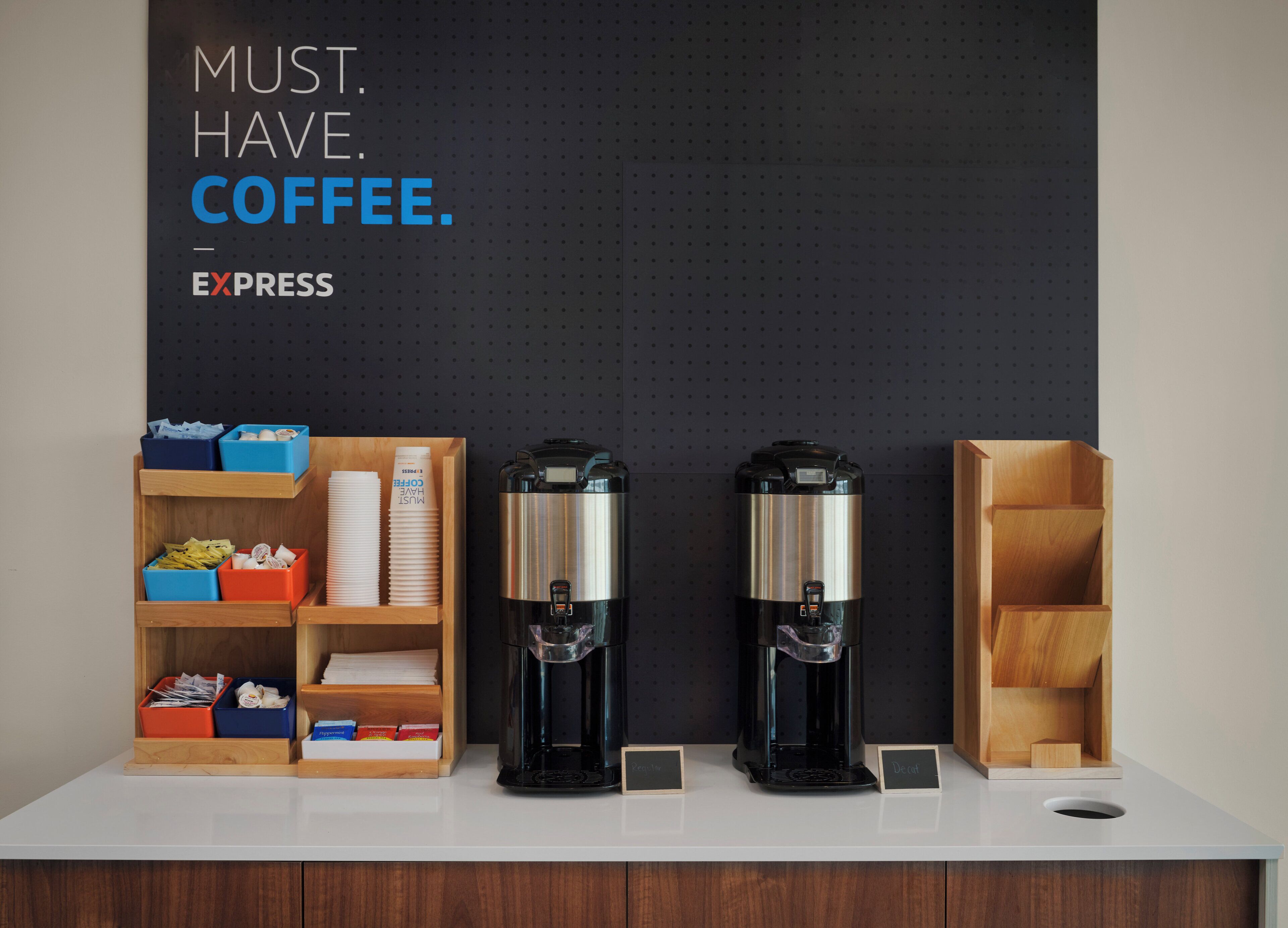 Un espace dédié au café, équipé de deux machines à café et de récipients étiquetés contenant des dosettes de café.
