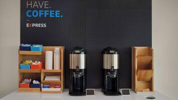A coffee station with two coffee makers and labeled containers of coffee pods.