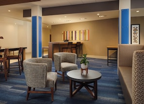 A hotel lobby with seating, a reception desk, and a colorful artwork on the wall. - Holiday Inn Express & Suites Lockport by IHG (Lockport)