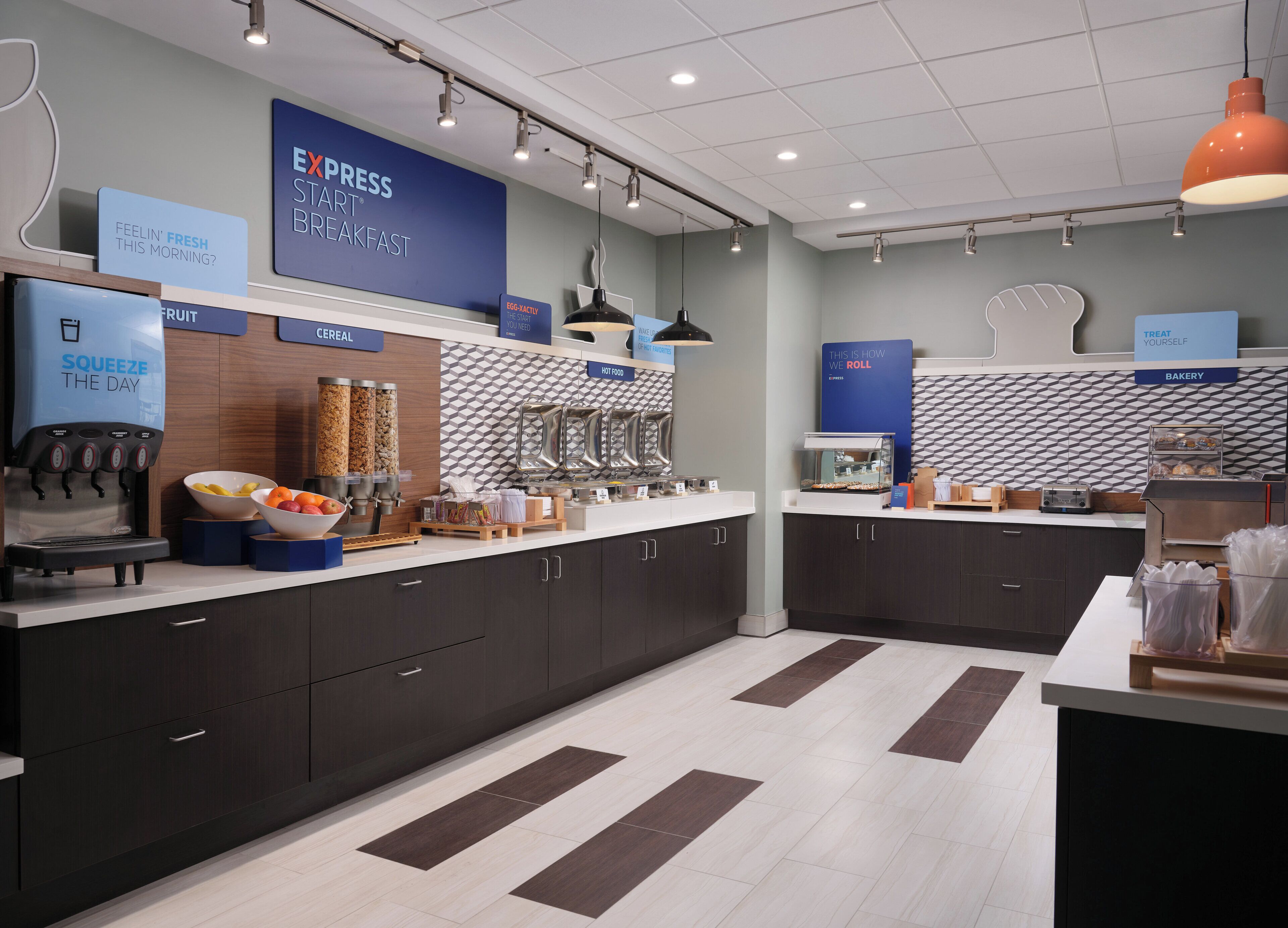 A modern breakfast area with a coffee machine, fruit bowl, cereal containers, and a bakery section.