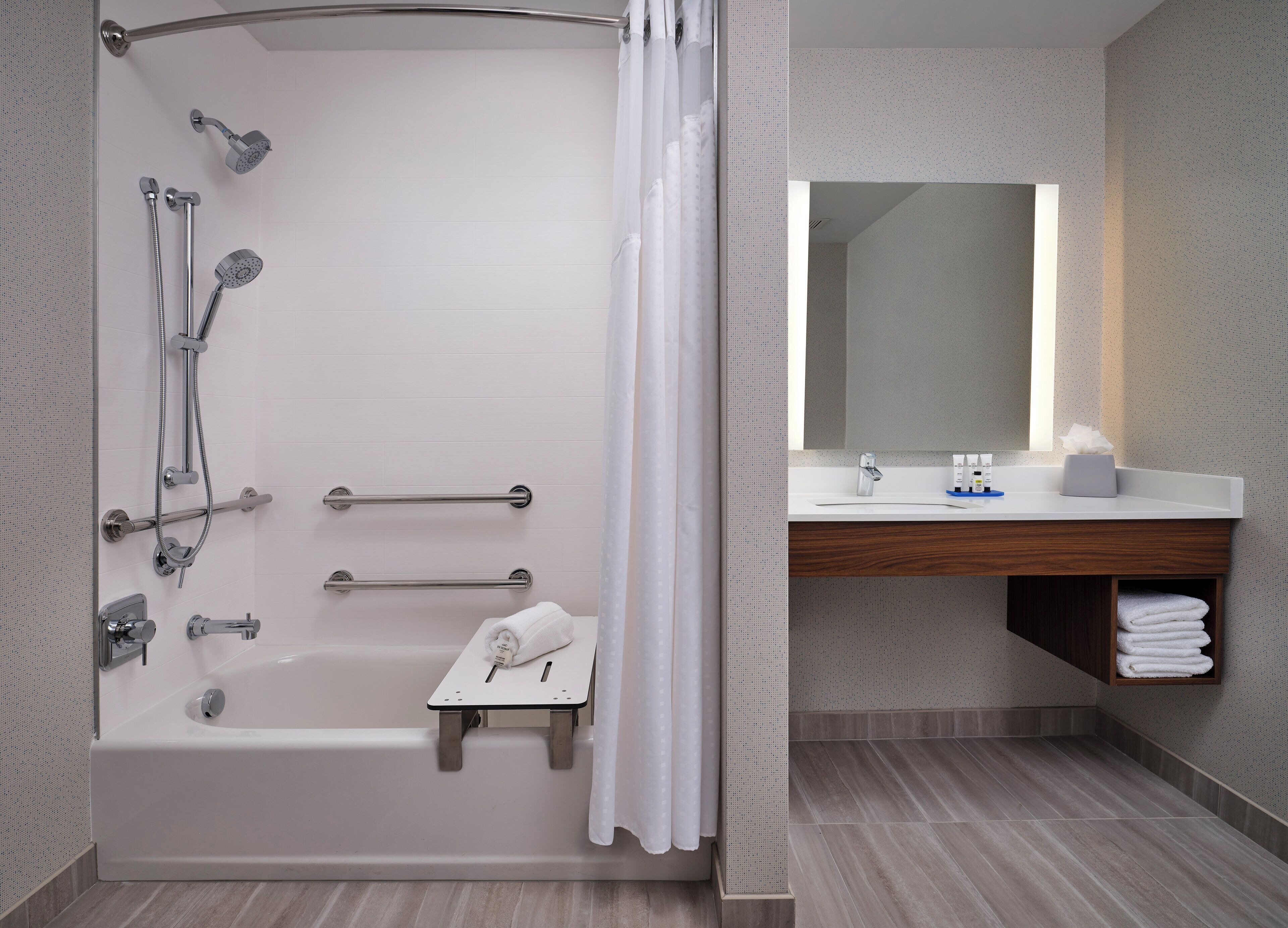 A modern bathroom with a bathtub, shower, and vanity.
