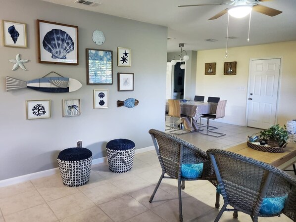 A dining area with a table, chairs, and a ceiling fan.