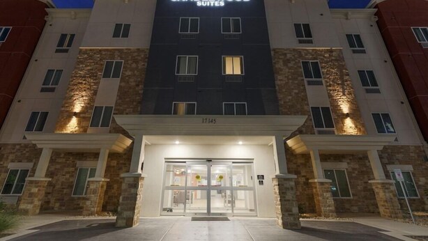 A hotel with a modern facade, a prominent entrance with glass doors, and a sign reading "CANDLEWOOD SUITES".